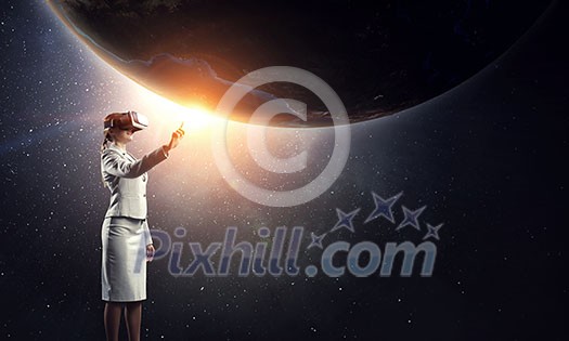 Businesswoman trying virtual reality glasses. Elements of this image are furnished by NASA