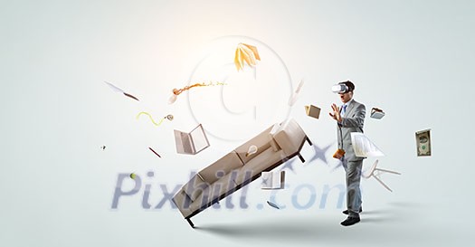 Young businessman wearing virtual helmet. Mixed media Young businessman wearing virtual helmet. Mixed media