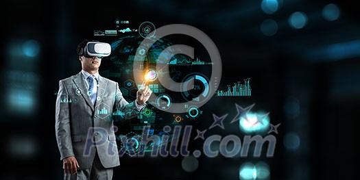 Young businessman wearing virtual helmet. Mixed media Young businessman wearing virtual helmet. Mixed media