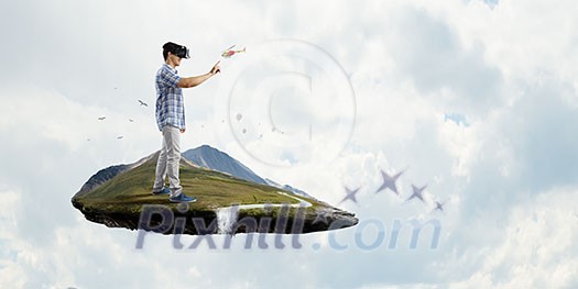 Young man wearing virtual helmet. Mixed media Young man wearing virtual helmet. Mixed media