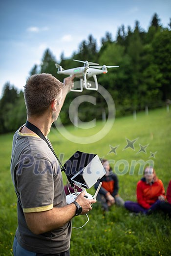 Man Operating a Drone by a Remote Control outdoors Man Operating a Drone by a Remote Control outdoors