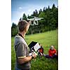 Man Operating a Drone by a Remote Control outdoors