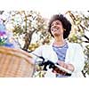 Happy young woman with bicycle in the park