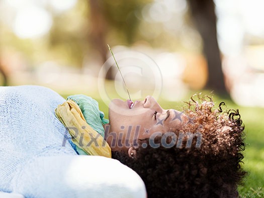 Young woman laying down in summer park, vacation and leisure concept