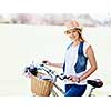 Happy young woman with bicycle in the park