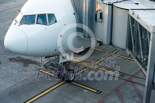 Aircraft with passage corridor/tunnel being prepared for departure from an international airport - Passangers boarding an airplane in a modern airport Aircraft with passage corridor/tunnel being prepared for departure from an international airport - Passangers boarding an airplane in a modern airport