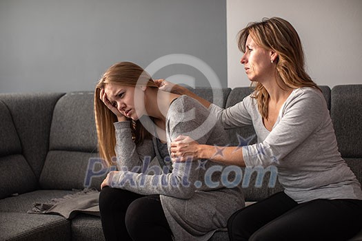 Depressed teen suffering from anxiety being taken care of by her caring mother