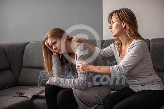 Depressed teen suffering from anxiety being taken care of by her caring mother Depressed teen suffering from anxiety being taken care of by her caring mother