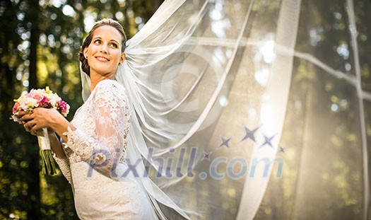 Brunette bride in fashion white wedding dress with makeup. Wedding day of bride in bridal gown. Beauty woman and bouquet. Fashion brunette model outdoors. Portrait beauty model in white bridal dress Brunette bride in fashion white wedding dress with makeup. Wedding day of bride in bridal gown. Beauty woman and bouquet. Fashion brunette model outdoors. Portrait beauty model in white bridal dress