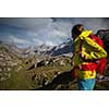 Pretty, young female hiker walking in high mountains (shallow DOF)