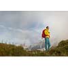 Pretty, young female hiker walking in high mountains (shallow DOF)