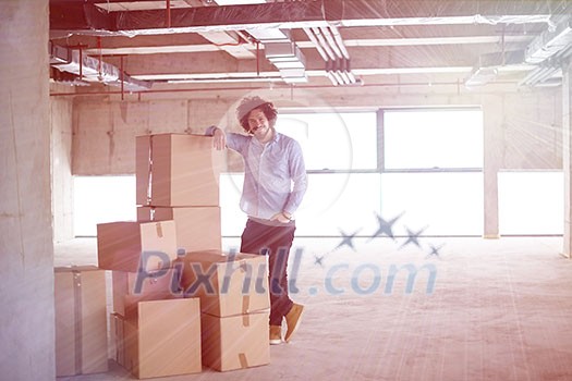 portrait of young businessman on construction site checking documents and business workflow with cardboard boxes around him in new startup office portrait of young businessman on construction site checking documents and business workflow with cardboard boxes around him in new startup office