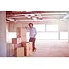 portrait of young businessman on construction site checking documents and business workflow with cardboard boxes around him in new startup office