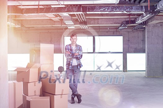portrait of young businessman on construction site checking documents and business workflow with cardboard boxes around him in new startup office portrait of young businessman on construction site checking documents and business workflow with cardboard boxes around him in new startup office