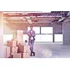 portrait of young businessman on construction site checking documents and business workflow with cardboard boxes around him in new startup office