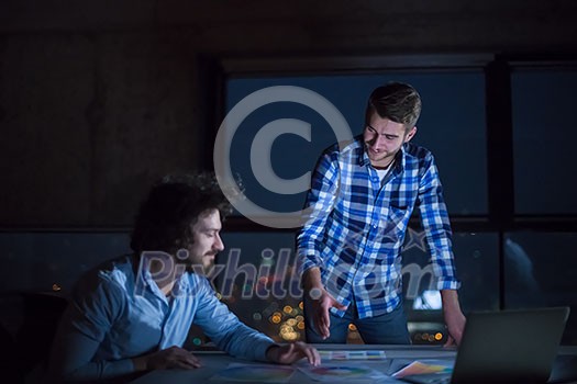 young team of business people in group, architect and engineer on construction site checking documents and business workflow using laptop computer in new startup office at night