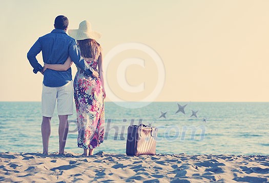 couple on beach with travel bag representing freedom and funy honeymoon concept couple on beach with travel bag representing freedom and funy honeymoon concept