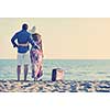 couple on beach with travel bag representing freedom and funy honeymoon concept