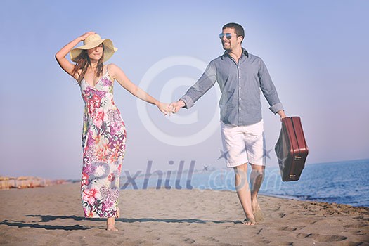 couple on beach with travel bag representing freedom and funy honeymoon concept couple on beach with travel bag representing freedom and funy honeymoon concept