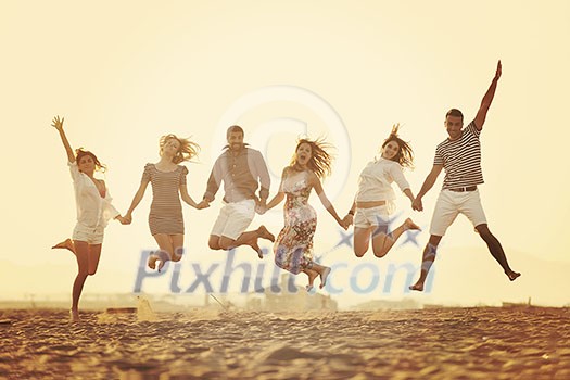 happy young people group have fun  run and jump  on beach beautiful sand  beach