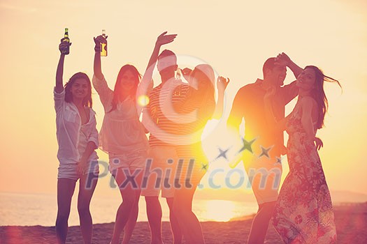 Group of young people enjoy summer party at the beach on beautiful sunset Group of young people enjoy summer party at the beach on beautiful sunset