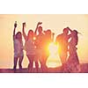Group of young people enjoy summer  party at the beach on beautiful sunset