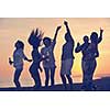 Group of young people enjoy summer  party at the beach on beautiful sunset