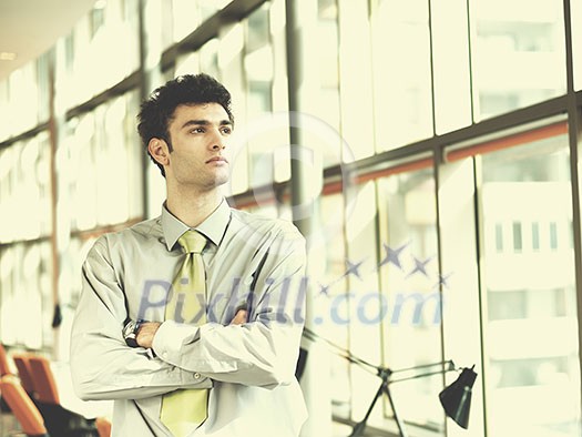 portrait of young business man at modern office  interior with big windows in background