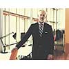 portrait of senior business man with grey beard and hair alone i modern office indoors