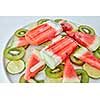 Berry healthy ice cream lolly of lime, watermelon, kiwi ildom in a plate on a gray background. Cold dessert