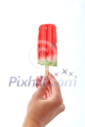 A woman's hand holds a piece of watermelon on a stick on a white background with space for text. The concept of fruit ice popsicle