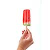 A woman's hand holds a piece of watermelon on a stick on a white background with space for text. The concept of fruit ice popsicle