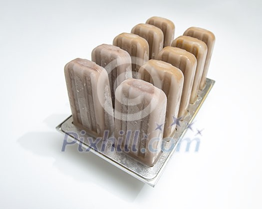 Plastic molds with coffee homemade ice cream on white background with copy space. Cold dessert