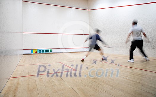 Squash players in action on a squash court (motion blurred image; color toned image) Squash players in action on a squash court (motion blurred image; color toned image)