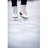 Young woman ice skating outdoors on a pond on a freezing winter day