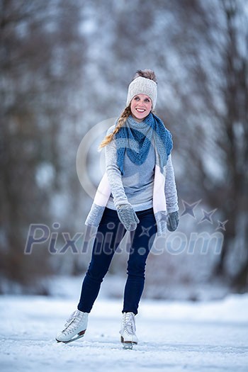 Young woman ice skating outdoors on a pond on a freezing winter day