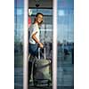 Young woman with her luggage at an international airport, before going through the check-in and the security check before her flight