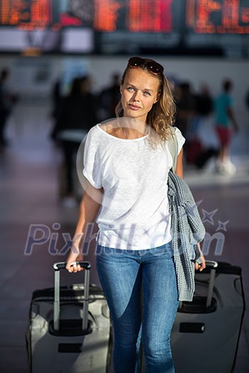 Young woman with her luggage at an international airport, before going through the check-in and the security check before her flight