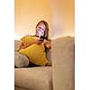 Cute young woman on a comfortable sofa in her modern apartment using her cell phone