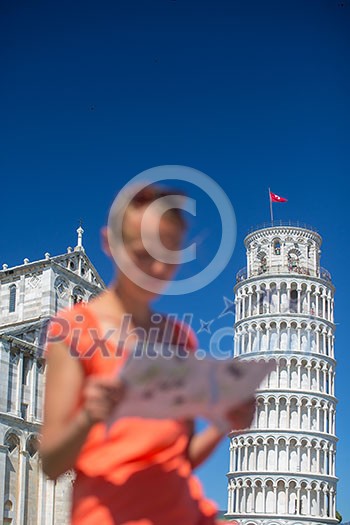 Gorgeous female tourist with map admiring the Leaning Tower of Pisa, Tuscany, Italy (shallow DOF)
