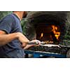 Cook baking pizza in a traditional stone wood fired oven