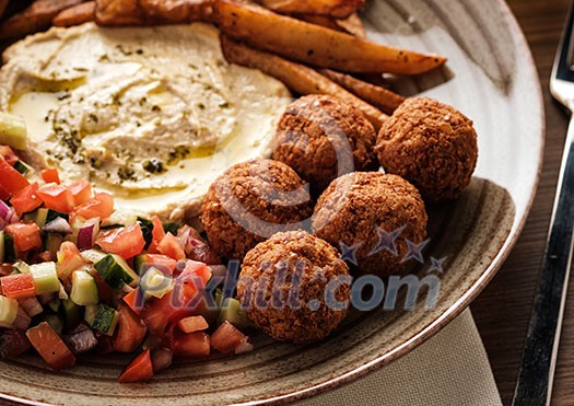 Close-up of Traditional falafel balls with salad and hummus on a plate. Close-up of Traditional falafel balls with salad and hummus on a plate.