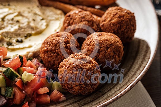 Close-up of Traditional falafel balls with salad and hummus on a plate. Close-up of Traditional falafel balls with salad and hummus on a plate.