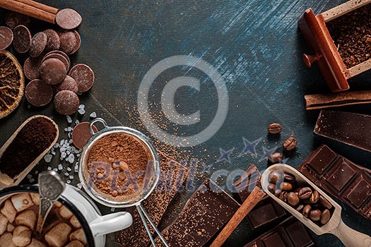 Dark and milk chocolate bars with dry orange slices, cinnamon sticks and coffee beans on blue background. Copyspace. Dark and milk chocolate bars with dry orange slices, cinnamon sticks and coffee beans on blue background. Copyspace.