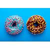 Colorful tasty glazed donuts on a colored background.
