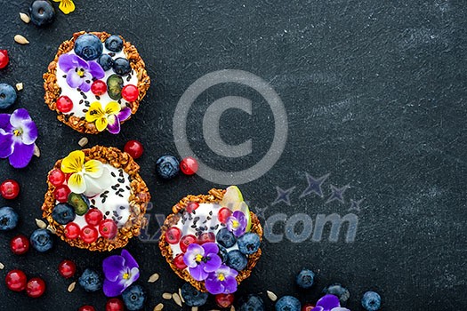 Dessert with sunflower seeds, yogurt and fresh berries on black wooden table Dessert with sunflower seeds, yogurt and fresh berries on black wooden table