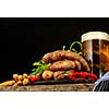 Grilled sausages with a glass of beer on a wooden table. Rustic style. Snacks for the Oktoberfest.