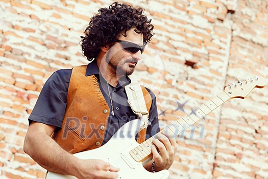A street musician playing his guitar A street musician playing his guitar