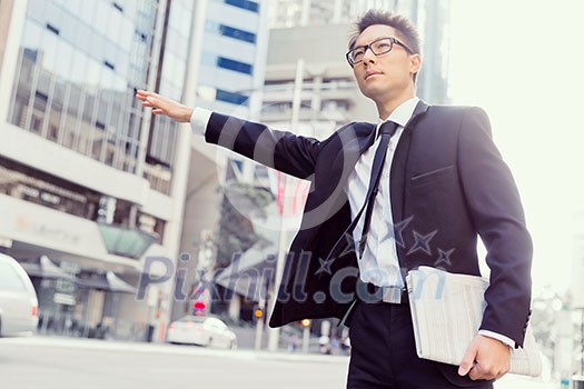 Businessman trying to catch a taxi in business cuty district