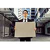 Businessman in a city street holding a blank banner